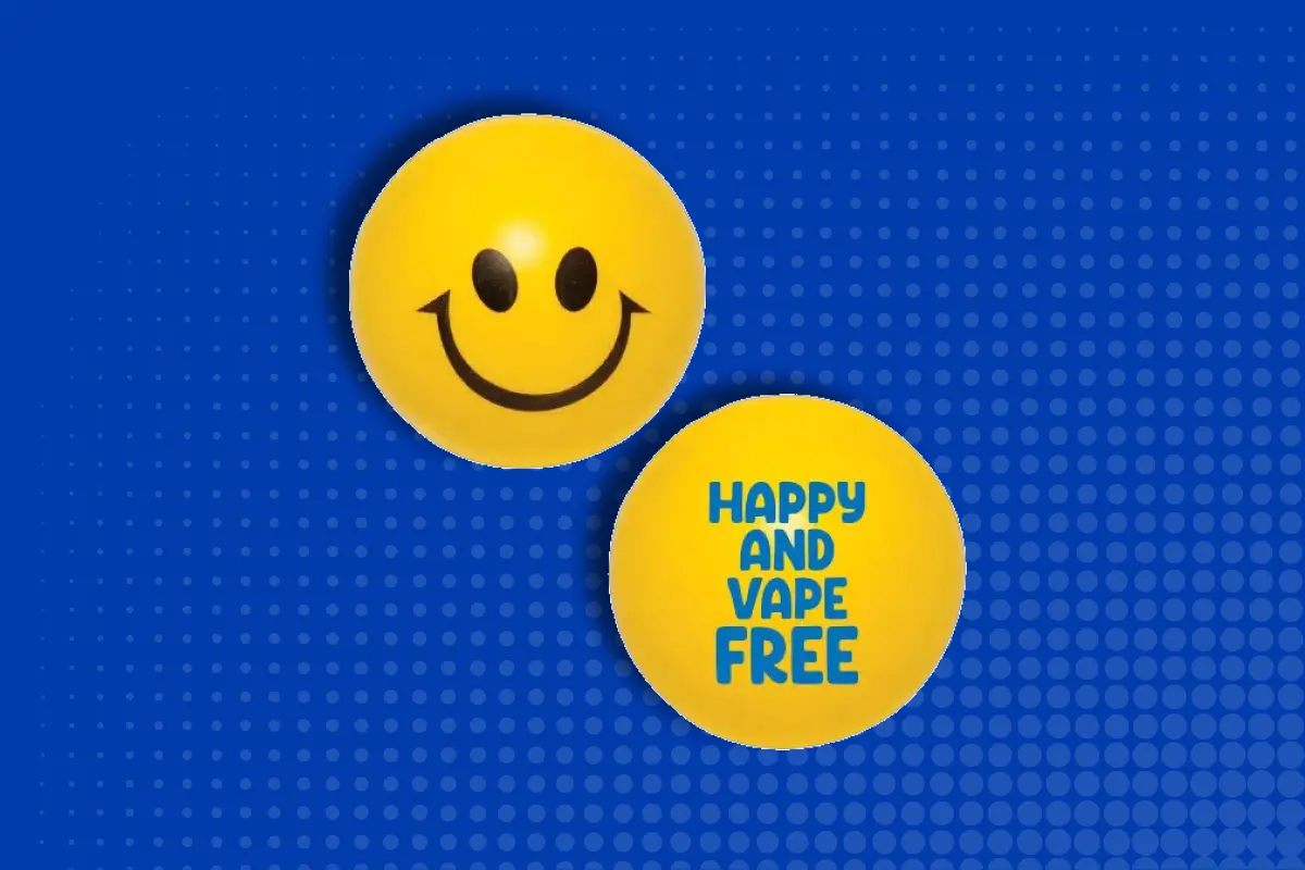 Two yellow smiley-face stress balls on a blue dotted background, one showing the message 'Happy and Vape Free.'