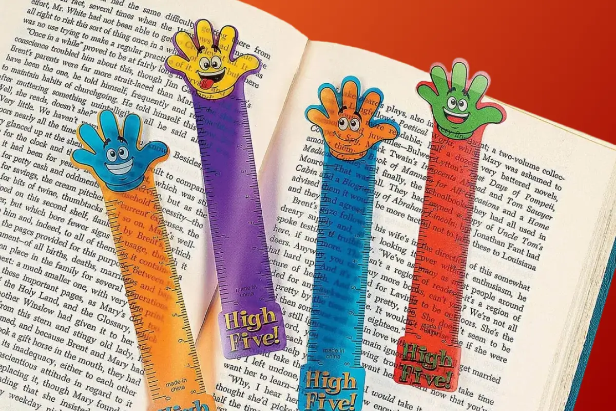 Colorful “High Five!” hand-shaped bookmarks placed across the open pages of a book.